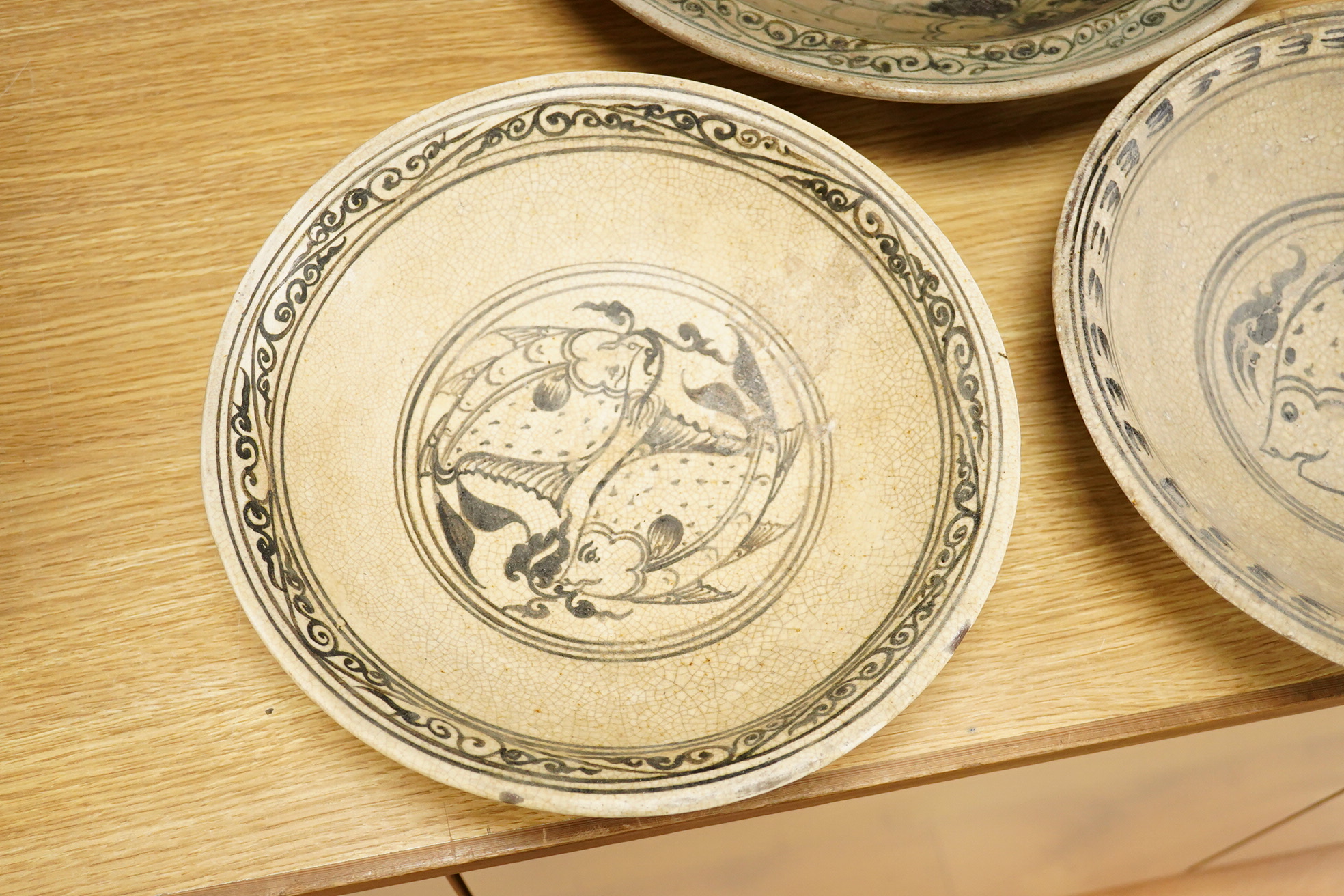 A group of three Thai underglaze blue or black crackle glaze dishes, two decorated with fish, largest 38cm in diameter